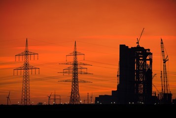 Fototapeta premium Power plant, power lines and wind turbines at sunset