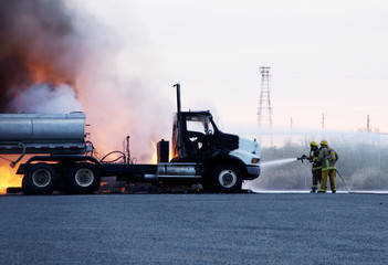 Firemen fight a truck fire.
