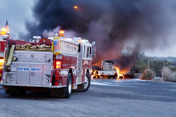 Firemen fight a fire that has involved  industrial trucks.