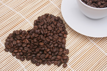 Heart of coffee beans  with coffee cup.