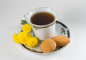 Cup of tea with cookies and flowers isolated