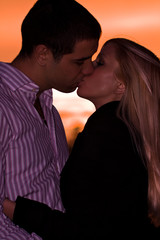 young couple kissing in sunset