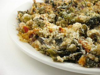 Mixed green vegetables on a white plate on a white background