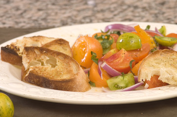 plate of tomato salad with red, green and yellow tomato's