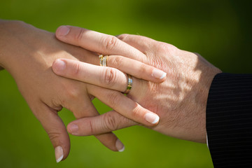 man and woman hands with spot sunlight on wedding rings