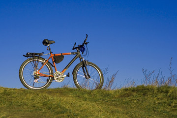 Fototapeta premium sports bicycle on an autumn meadow against the blue sky