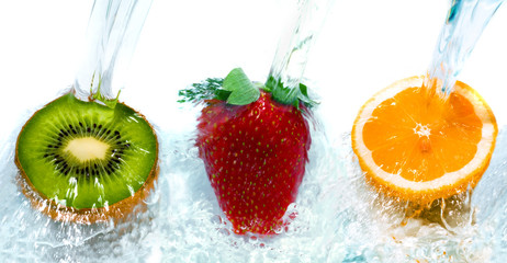 Fresh fruit jumping into water with a splash.