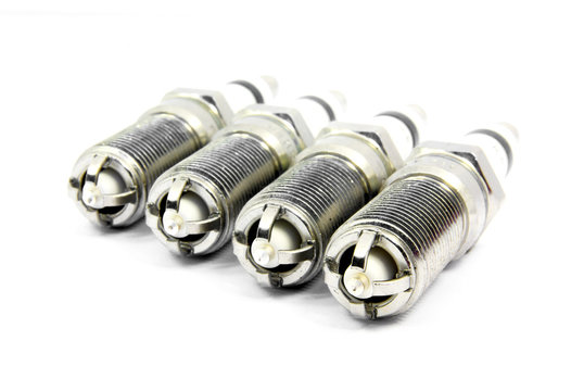 Detail view of an engine spark plugs over white background.