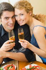 Young couple celebrating with champagne at home