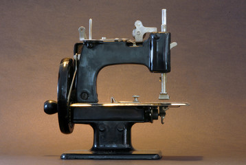 A vintage sewing machine against a black background