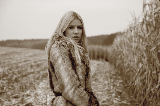 blonde dressed in fur coat in  corn field photo