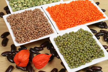 All sorts of beans and cereals sorted in ceramic containers.