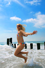 Happy woman jumping on the beach