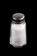 Close-up shot of a salt shaker on black background.