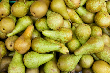 A large bulk bin of pairs at a fresh produce stand