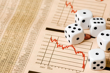 Dice and stock market charts in the newspaper