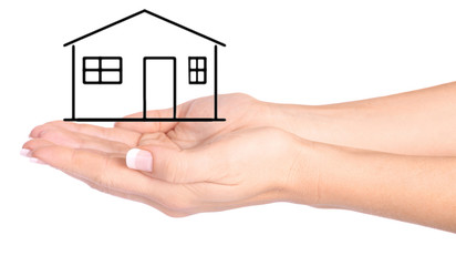 Hands protecting drawn house on the white background