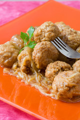 orange decorated platter with meat balls on onions sauce