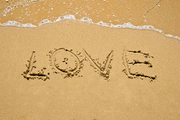 inscription Love on a sand at sunny day