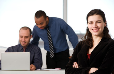 three business associates with a grey laptop