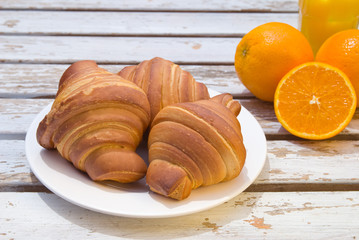 Table set with croissants and fresh orange