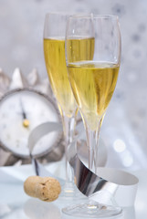Champagne to toast in the New Year with clock set at midnight