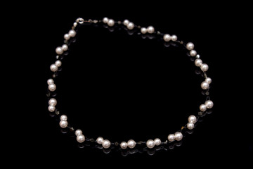 A pearl beads necklace isolated on black background.
