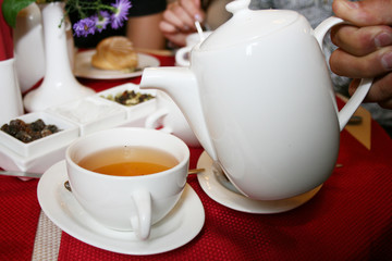 A white tea cup and saucer set. white teapot