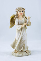 Little girl angel with hand bell on grey background