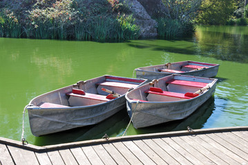 Three boats docked on a lake on a sunny day
