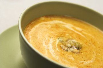 A bowl of pumpkin soup, shallow dof, focus is on seeds.