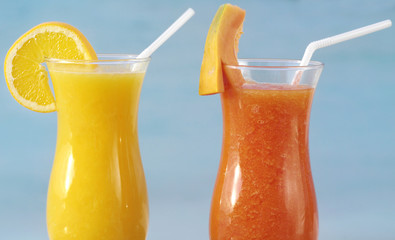 two fresh juice orange and papaya on blue sky