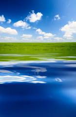 Obraz na płótnie Canvas green field and blue water