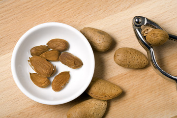 nutcracker, almonds in and around bowl