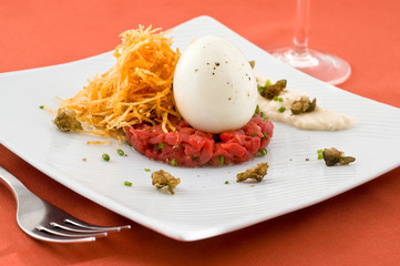 Gourmet dish with egg and raw meat. Studio shot.