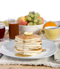 A pile of fresh pancakes with melted butter and syurp.