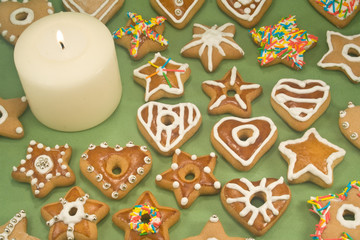 White pillar candle surrounded by gingerbread cookies