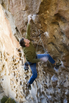 Climber clinging to an overhanging rock face.