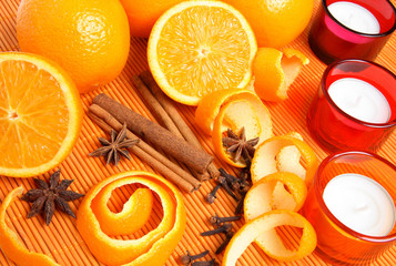 Oranges, Christmas spices and candles in warm light.