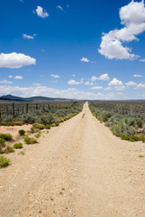 a dirt road heads straight into the deep blue sky