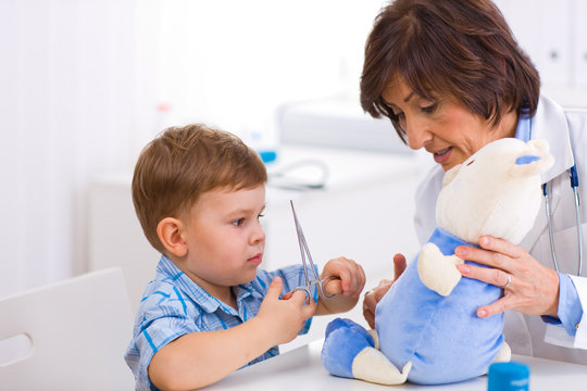 Senior female  pediatrician playing with child