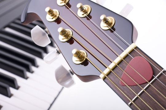 Close up of guitar head and keyboard - abstract music concept