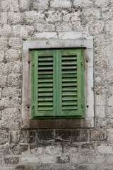 Fototapeta na wymiar green window on stone house