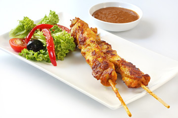 Chicken kebabs and salad.  Skewered satay chicken