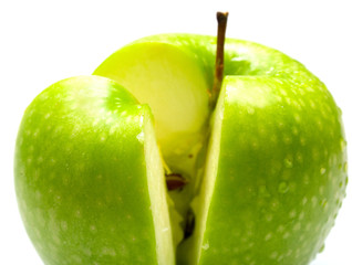 The ripe juicy green apple covered by water drops. Isolation