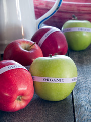 Red & green organic apples on a rustic wooden table