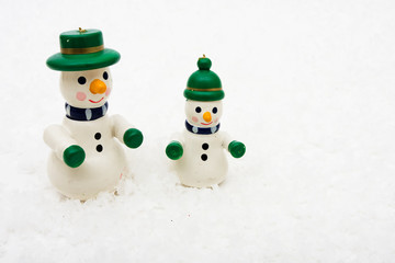 Snowman ornaments sitting on snow