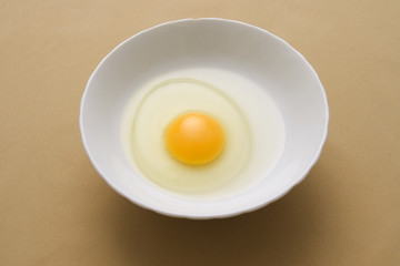 Egg yolk and egg white inside white bowl