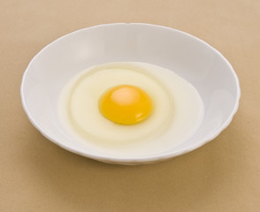 Egg yolk and egg white inside white bowl