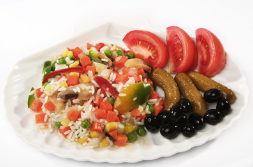 Risotto on a plate with tomatoes, olives and cucumbers